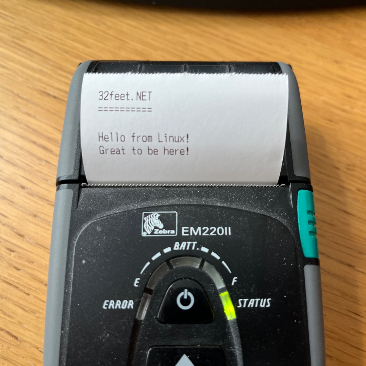Zebra Bluetooth thermal printer showing the output of a test application running on a Raspberry Pi. Message reads "32feet.NET Hello from Linux! Great to be here!"